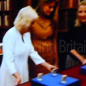 Inspecting miniature books for Queen Mary's doll house